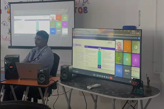 Mentor reviewing a web UI dashboard design on a large screen during a UX class
